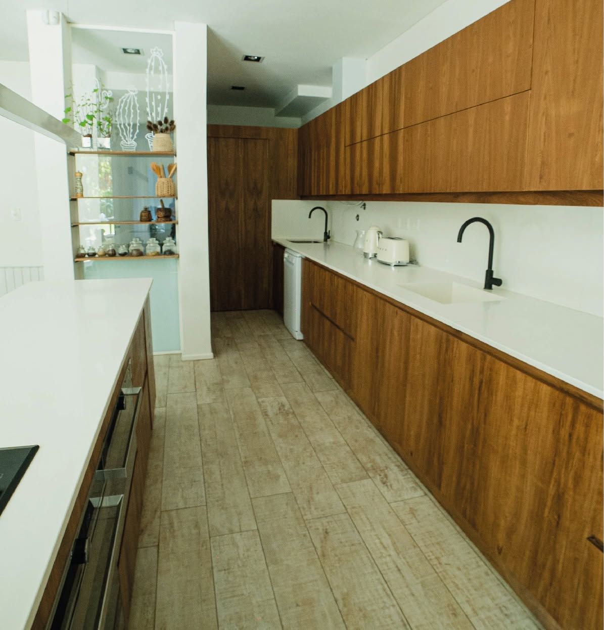 Cocina larga en nogal con mesada blanca